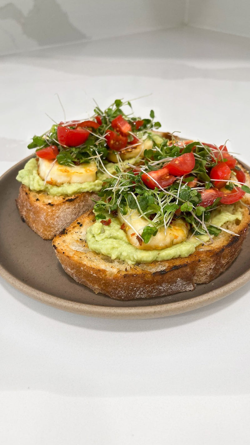 Avocado toast topped with fresh Planted Detroit microgreens and cherry tomatoes.