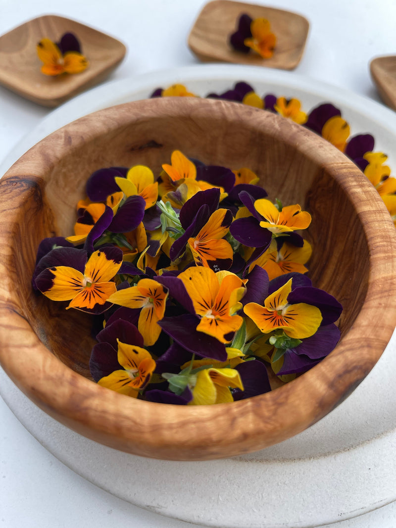 Fresh edible flowers in a wooden bowl at Planted Detroit