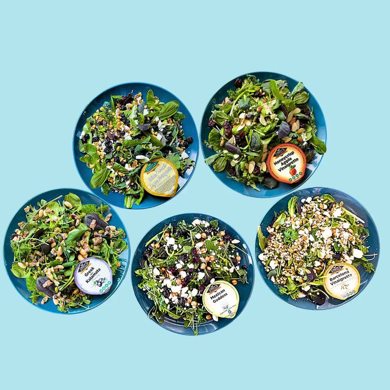 Assortment of Planted Detroit ready-to-eat salad bowls arranged to showcase fresh greens and colorful ingredients.