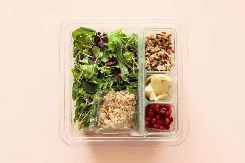 Planted Detroit salad box with mixed greens, wild rice, shaved cheese, granola, and pomegranate seeds.