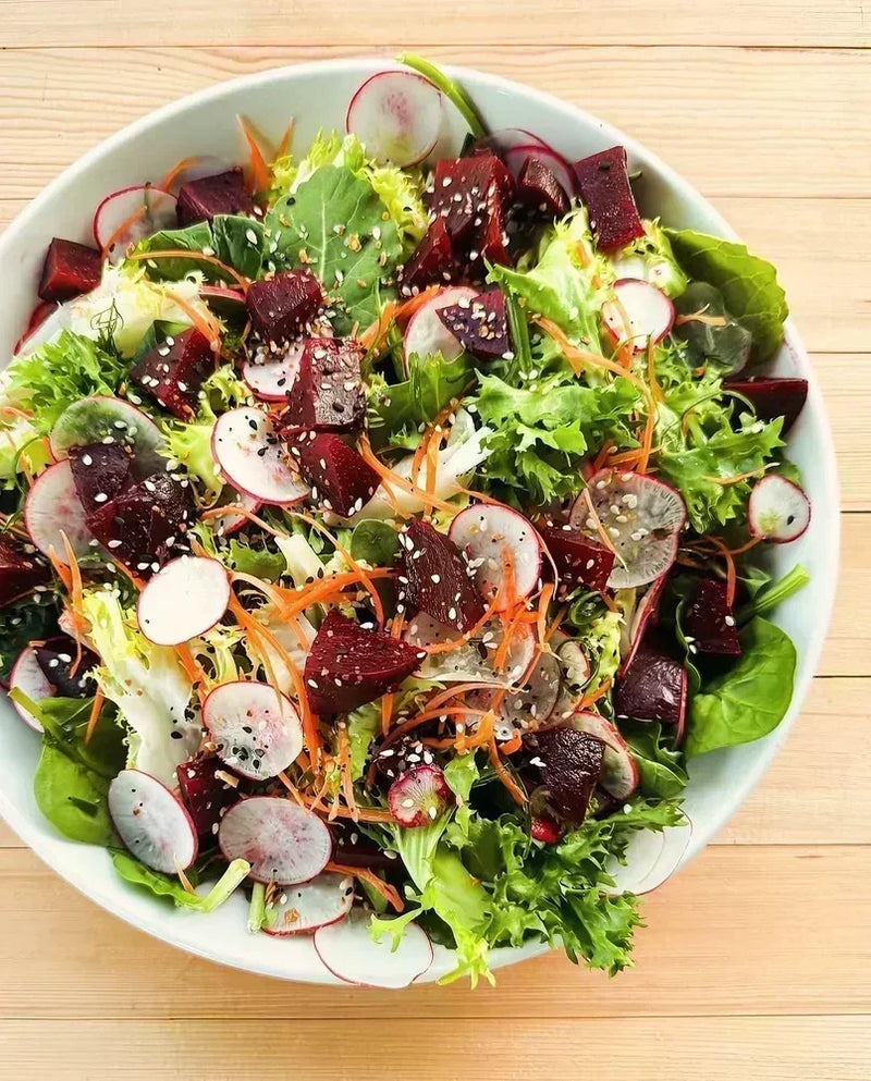 Planted Detroit fresh beet and mixed greens salad with radishes, carrots, and sesame seeds.